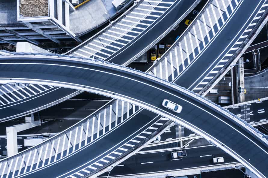 Aerial view of highway overpasses with one car on the top overpass